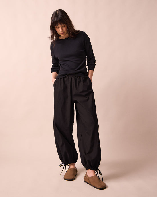 model wears codi black textured cotton trousers right