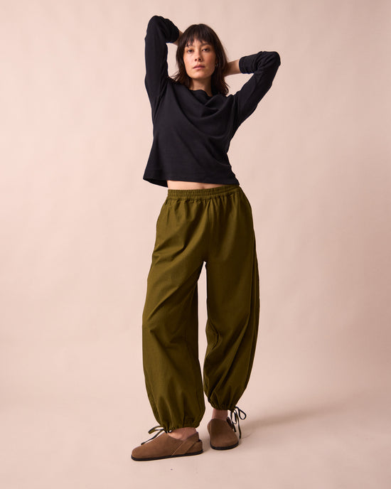 model wears codi dark olive textured cotton trousers left