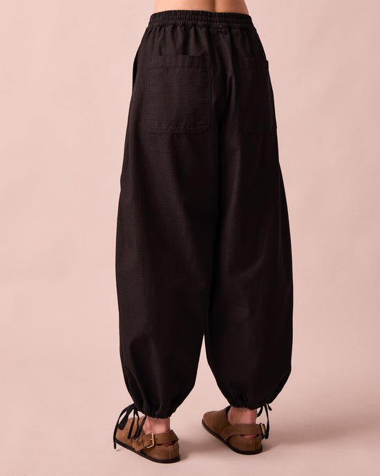 model wears codi black textured cotton trousers back