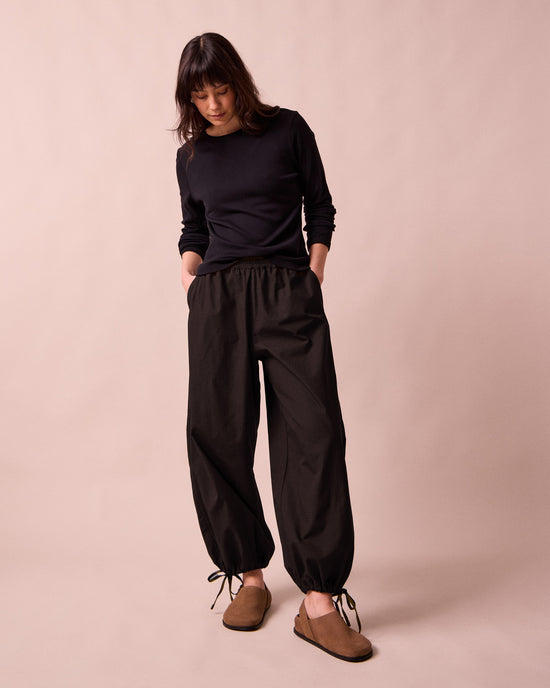 model wears codi black textured cotton trousers right