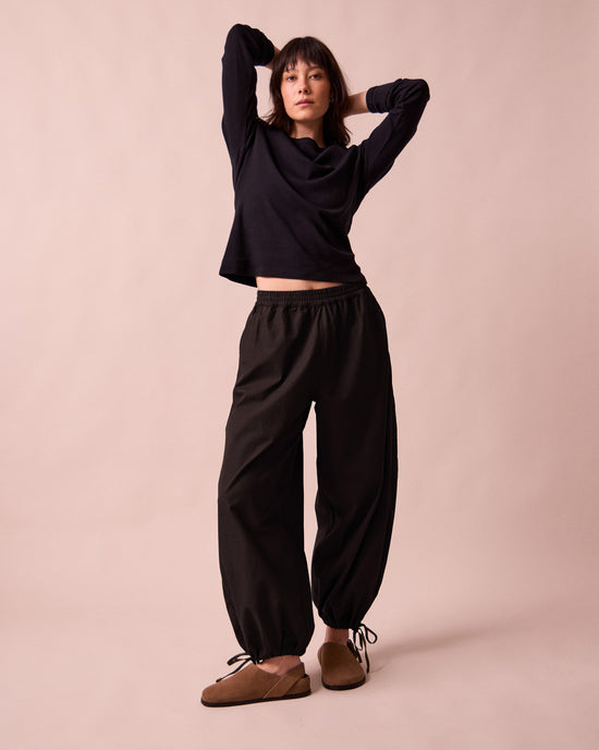 model wears codi black textured cotton trousers left