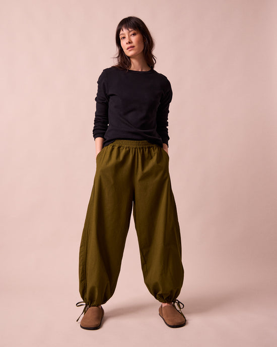 model wears codi dark olive textured cotton trousers right