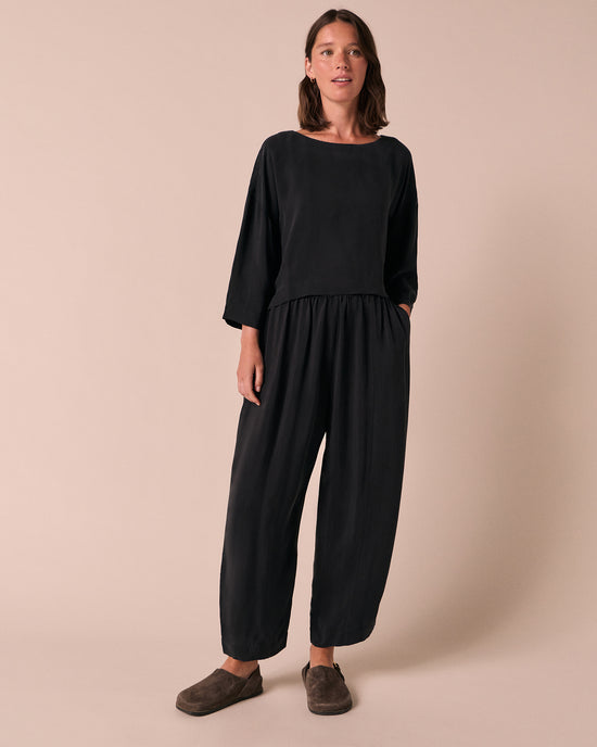 model wears mabel black cupro trousers left
