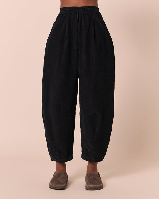 model wears daisy black cord trousers front