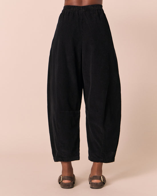 model wears daisy black cord trousers back