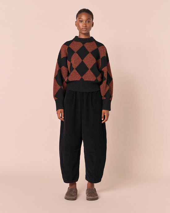 model wears daisy black cord trousers left