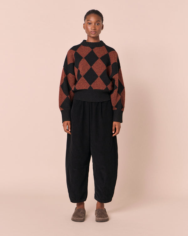 model wears daisy black cord trousers left
