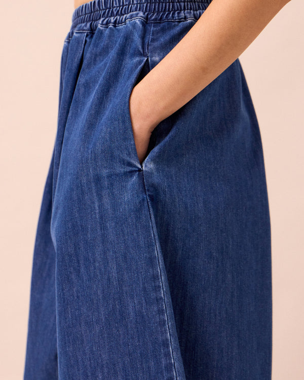 model wears daisy mid blue light weight denim trousers