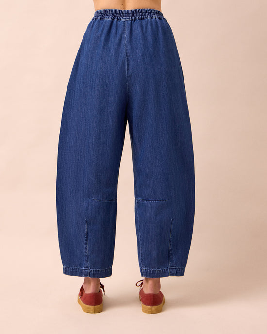 model wears daisy mid blue light weight denim trousers back