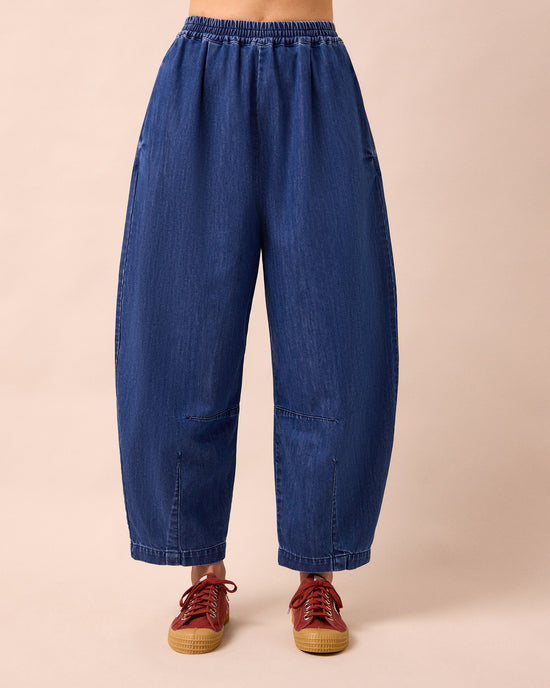 model wears daisy mid blue light weight denim trousers front