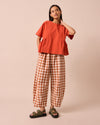 model wears daisy amber check cotton linen trousers left