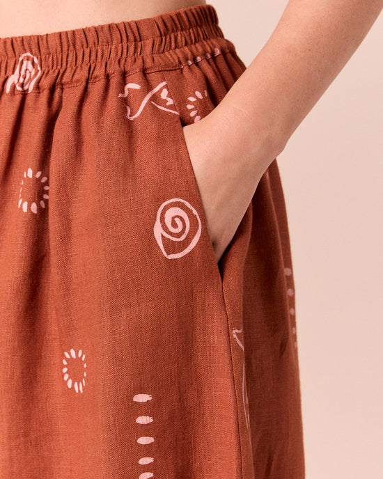 model wears daisy beachcomber print linen trousers.