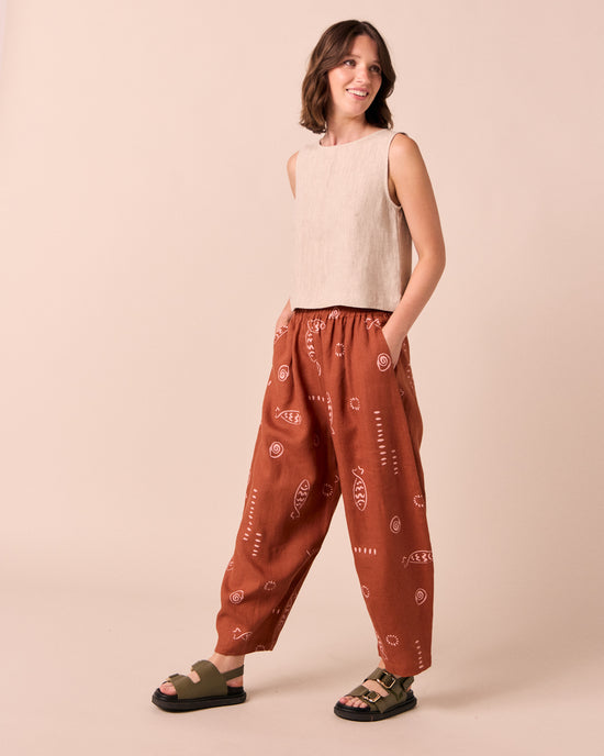 model wears daisy beachcomber print linen trousers.