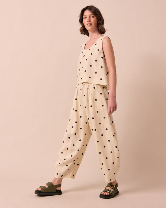 model wears daisy bone spot linen trousers right
