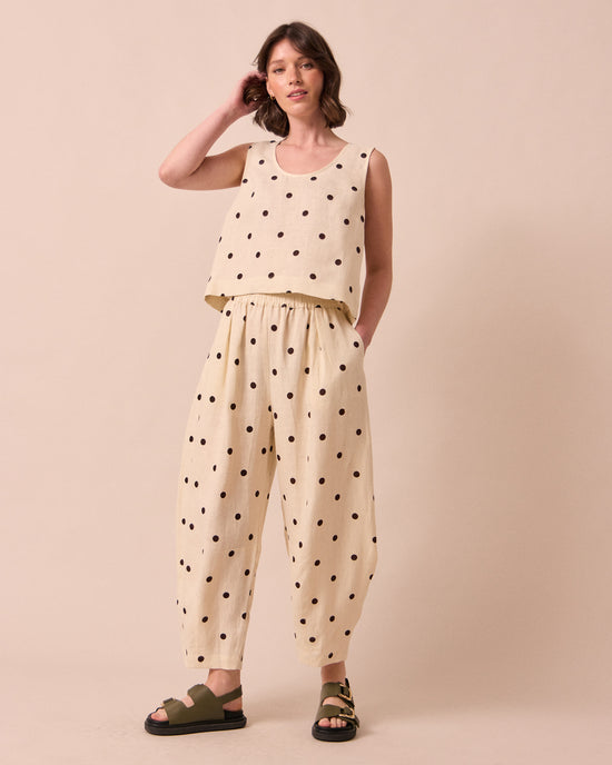 model wears daisy bone spot linen trousers left
