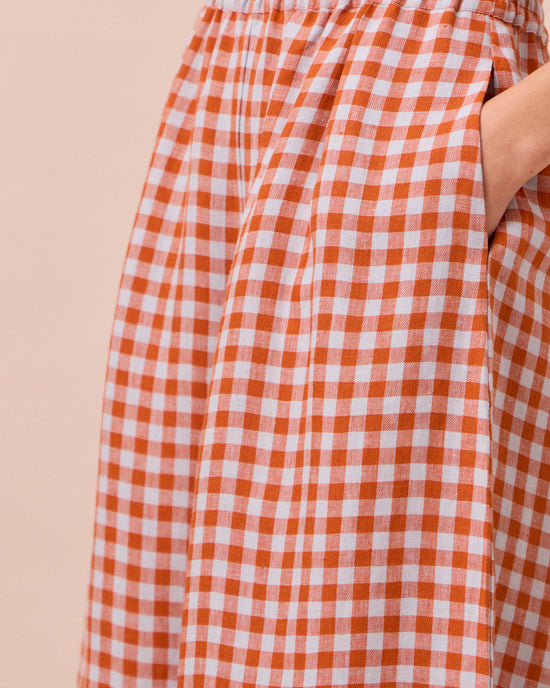 model wears daisy burnt orange gingham linen trousers 