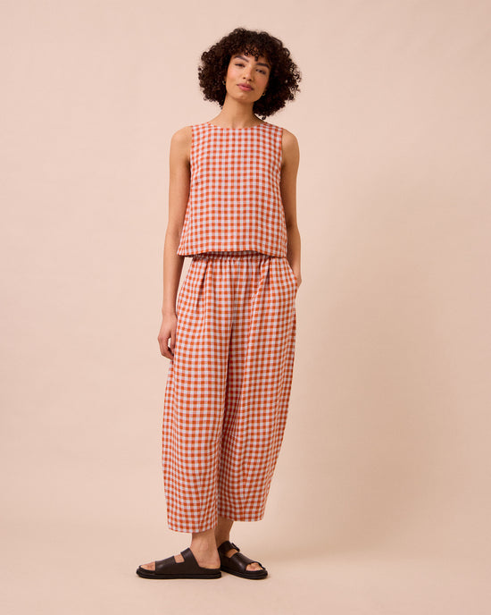 model wears daisy burnt orange gingham linen trousers right