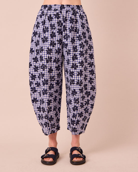 model wears daisy floral stamped gingham linen trousers front