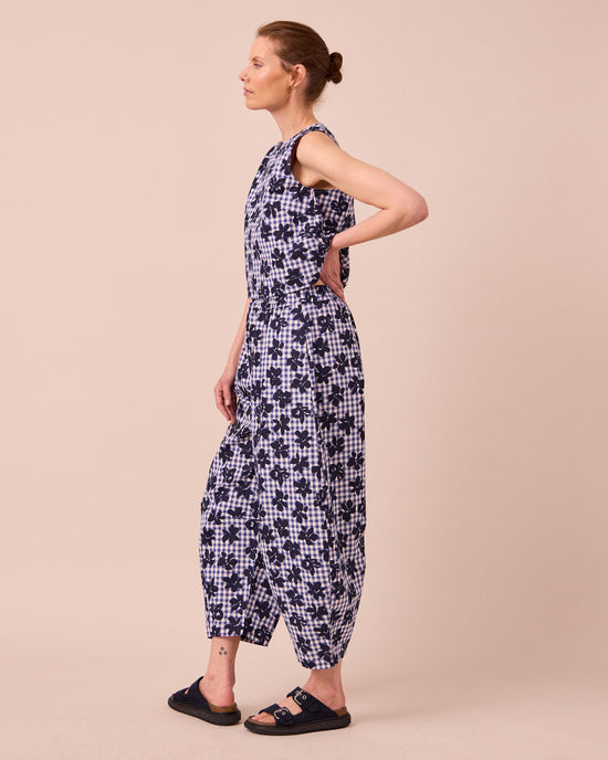 model wears daisy floral stamped gingham linen trousers right