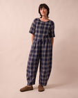 model wears daisy navy plaid linen trousers left