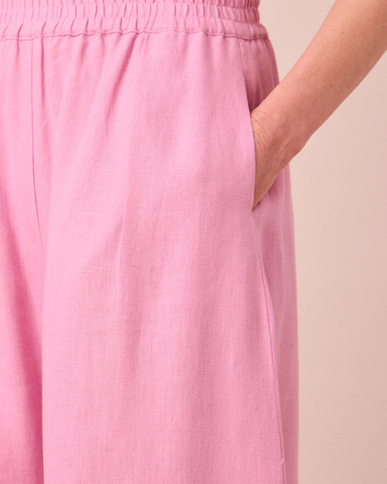model wears daisy rose pink linen trousers