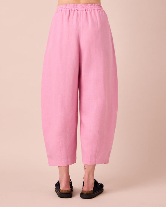 model wears daisy rose pink linen trousers back