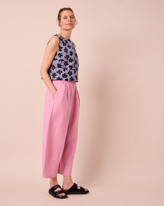 model wears daisy rose pink linen trousers left