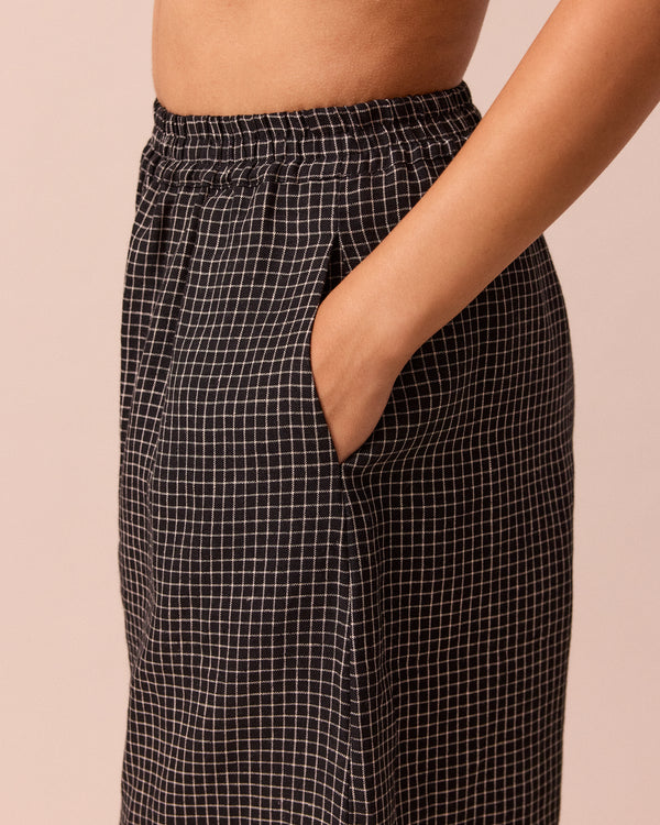 model wears daisy black mini grid linen trousers