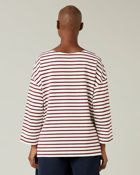 model wears cherry and ecru breton top