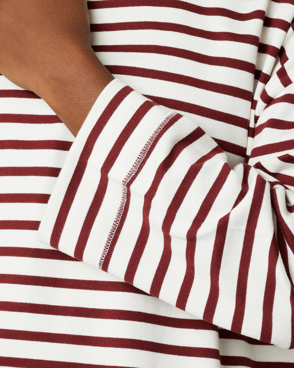 model wears cherry and ecru breton top