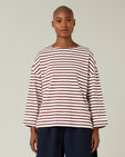 model wears cherry and ecru breton top