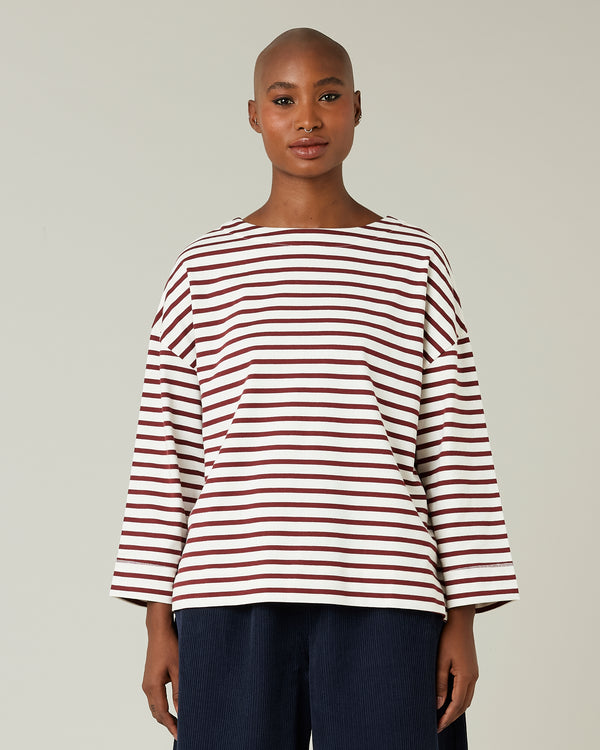 model wears cherry and ecru breton top