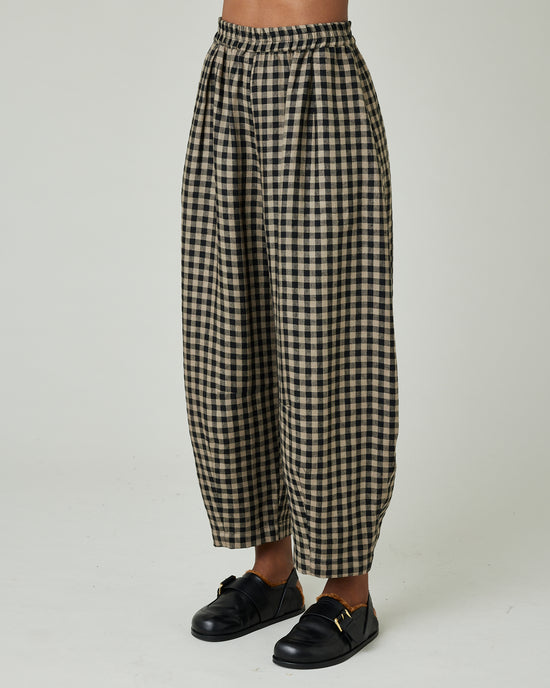 model wears coffee gingham daisy trousers left