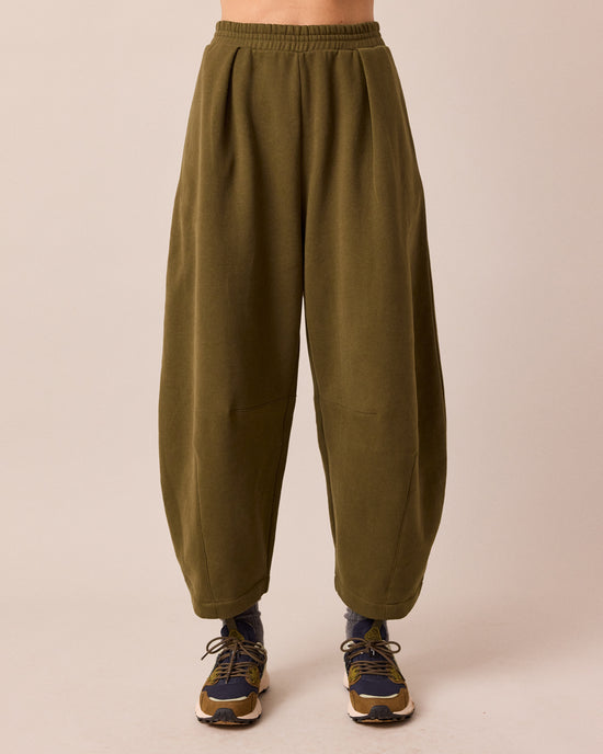 model wears daisy earth green jersey trousers front
