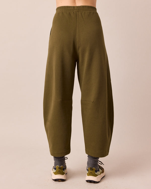 model wears daisy earth green jersey trousers back