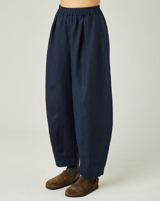 model wears navy linen daisy trousers left