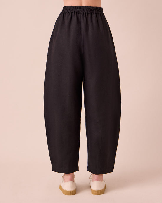 model wears daisy black linen trousers back