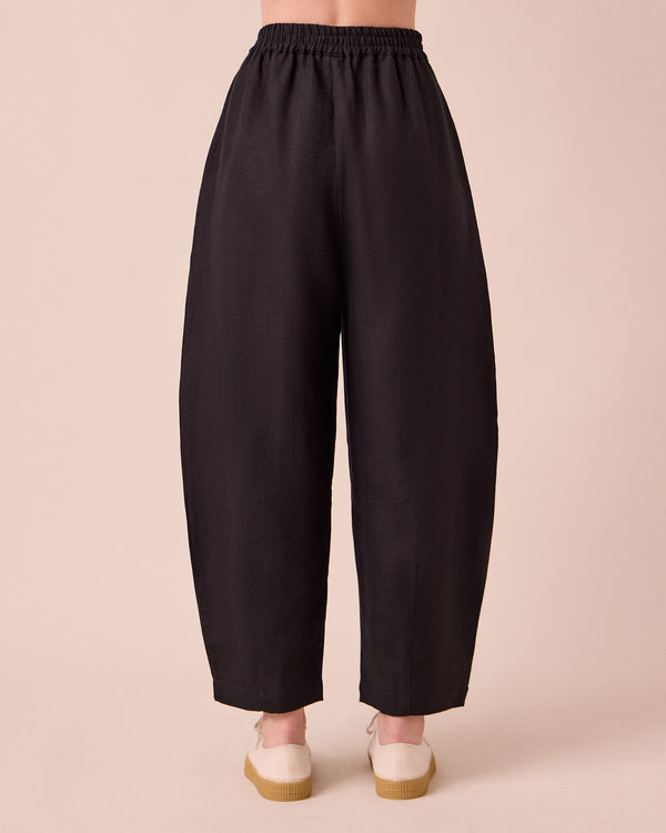 model wears daisy black linen trousers back