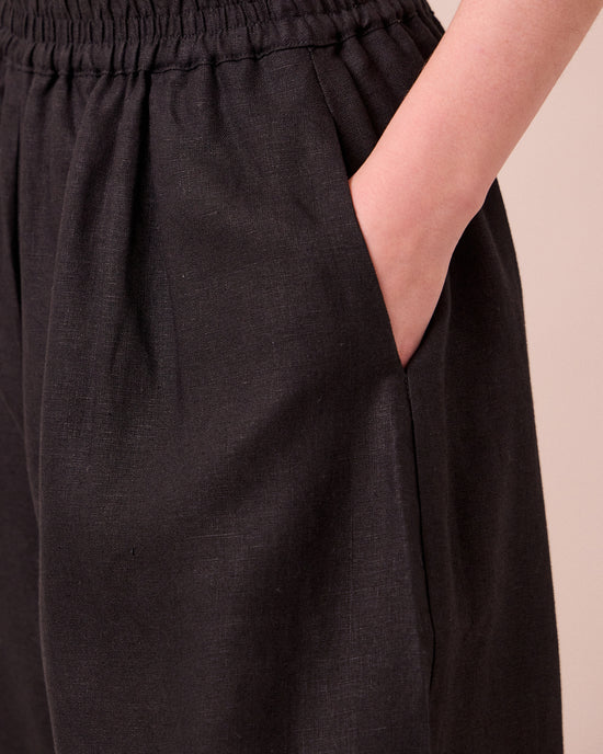 model wears daisy black linen trousers