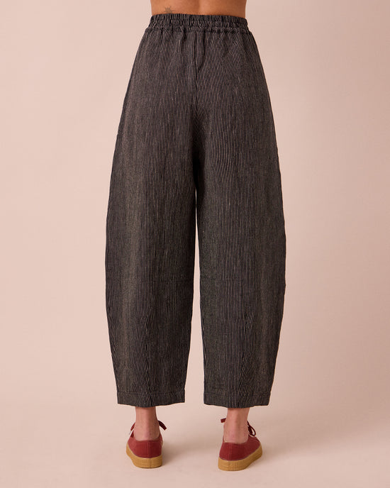 model wears daisy black and ecru pencil stripe linen trousers back