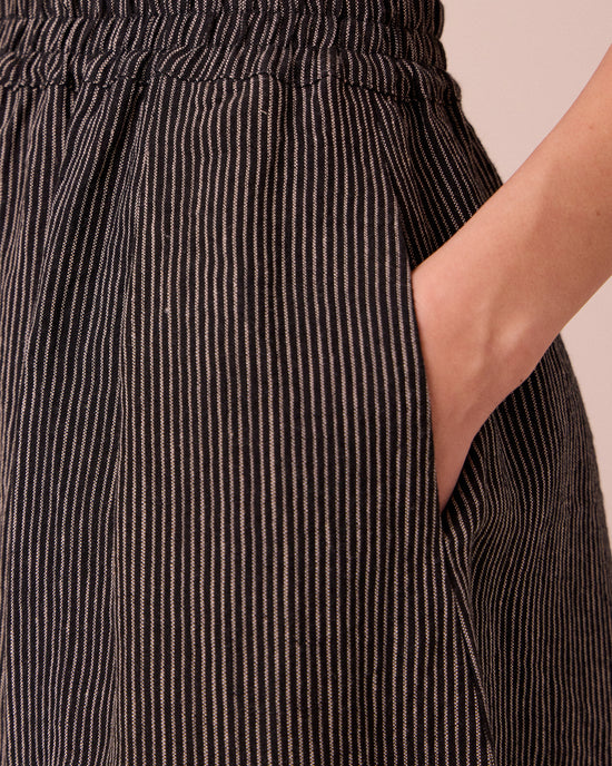 model wears daisy black and ecru pencil stripe linen trousers