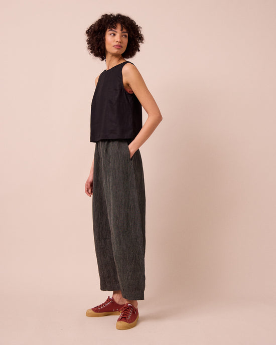 model wears daisy black and ecru pencil stripe linen trousers right
