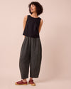 model wears daisy black and ecru pencil stripe linen trousers left