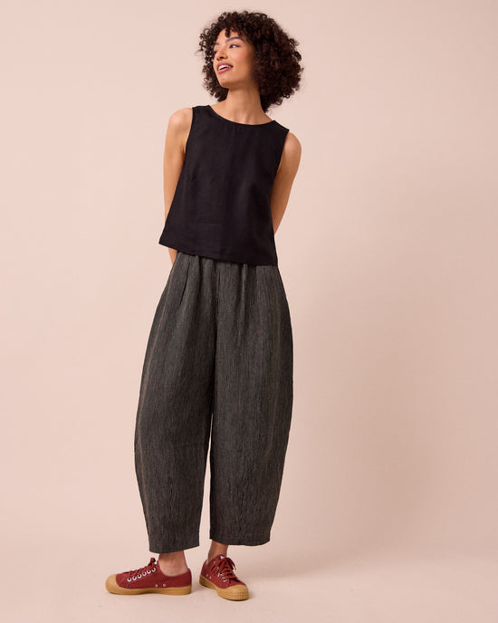 model wears daisy black and ecru pencil stripe linen trousers left
