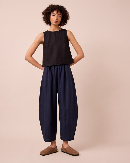 model wears daisy navy linen trousers left