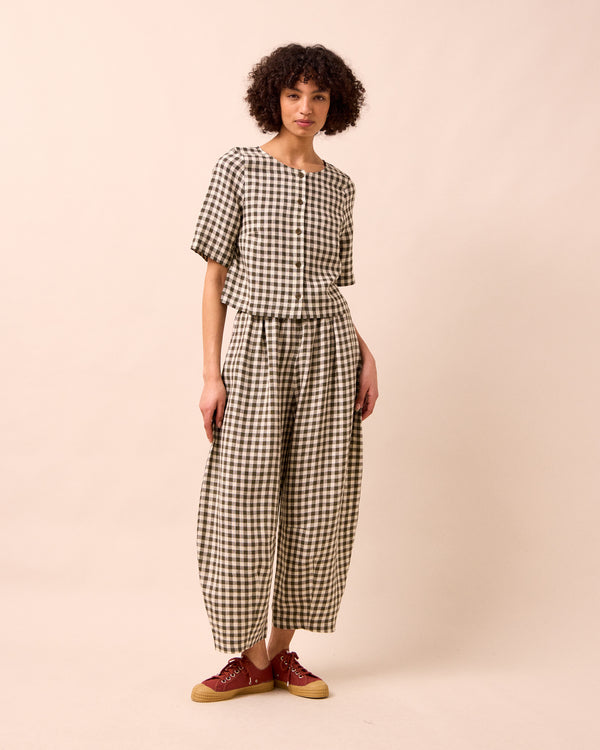 model wears daisy olive gingham linen trousers right