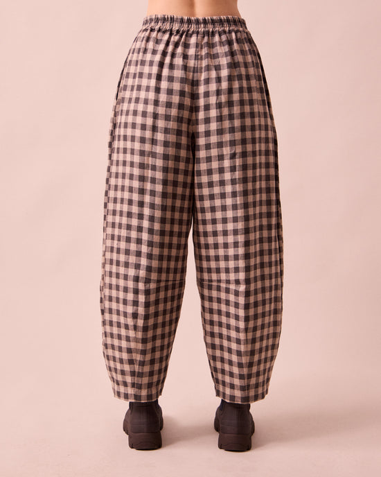model wears daisy stone gingham linen trousers back