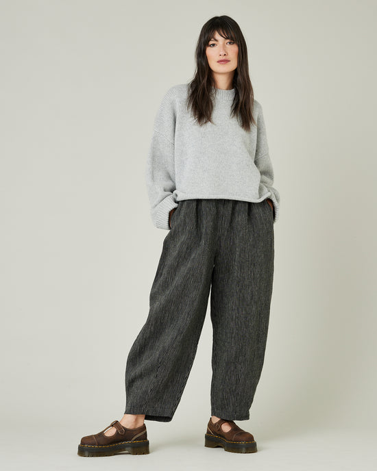 model wears black and ecru pencil stirpe daisy trousers