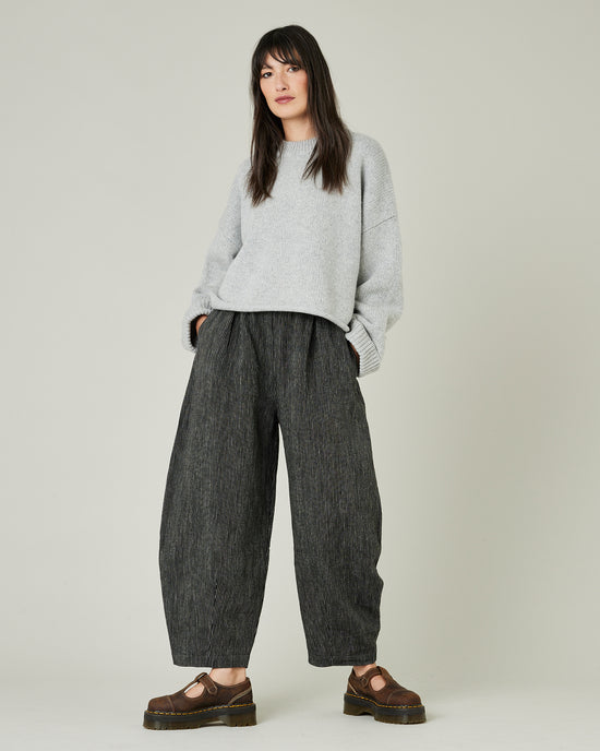 model wears black and ecru pencil stirpe daisy trousers