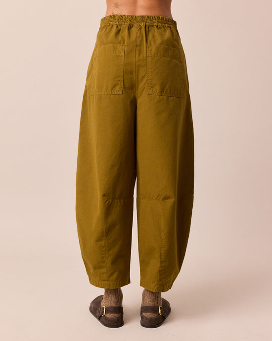 model wears dana golden olive cotton trousers back